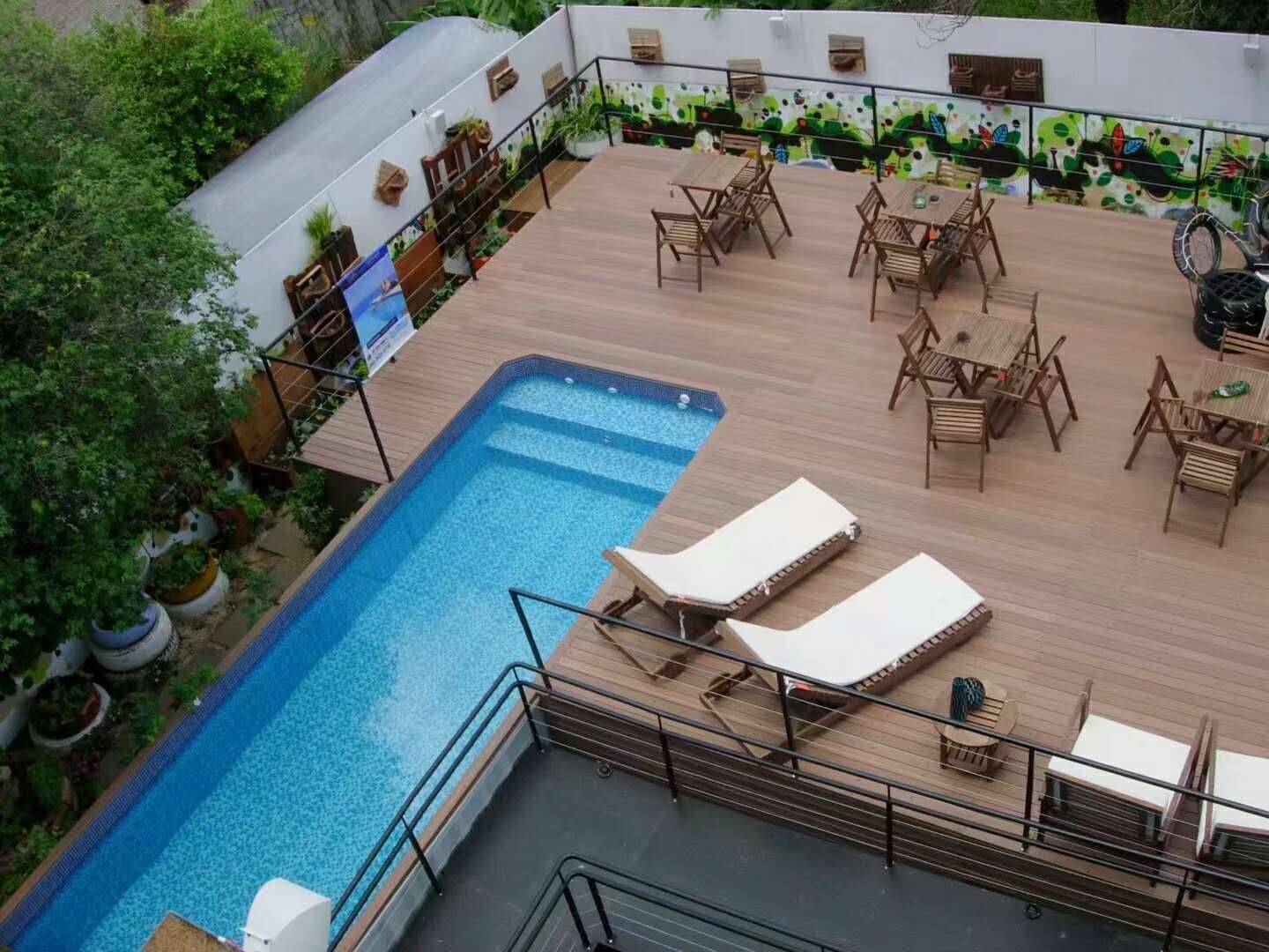 Hồ bơi trên sân thượng với khu bàn ghế và ghế nằm dọc theo các cạnh; minh họa cách chia chỗ nghỉ trong mặt bằng giới hạn.