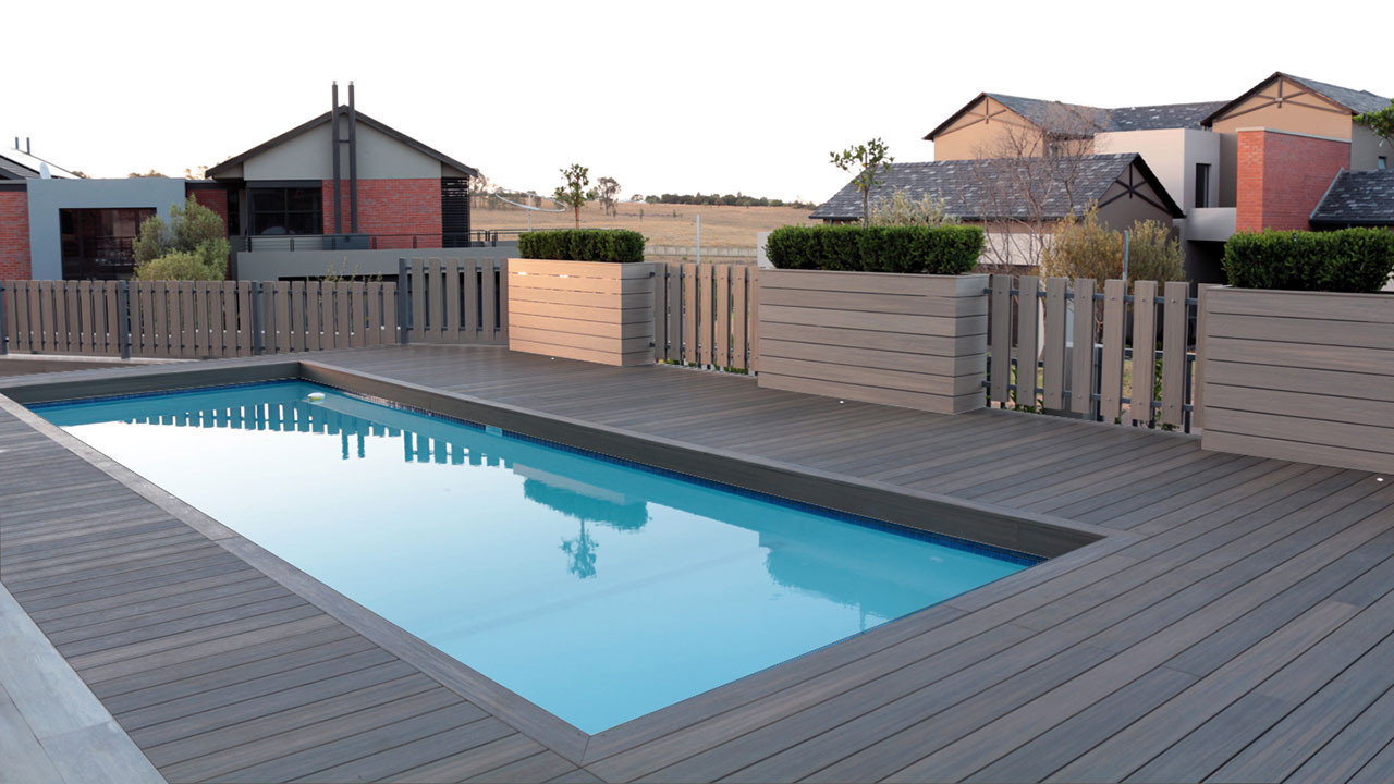 Sàn deck dạng thanh ôm quanh hồ bơi, kết hợp bồn cây ở rìa để phân chia khu vực và tạo điểm xanh.