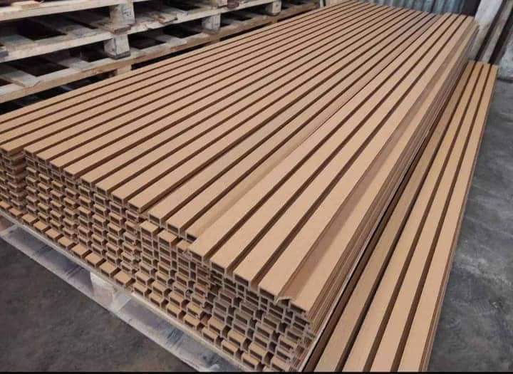 Góc nhìn từ dưới lên mặt tiền villa, thấy mảng tông gỗ cạnh khung cửa, ban công và mái đua.