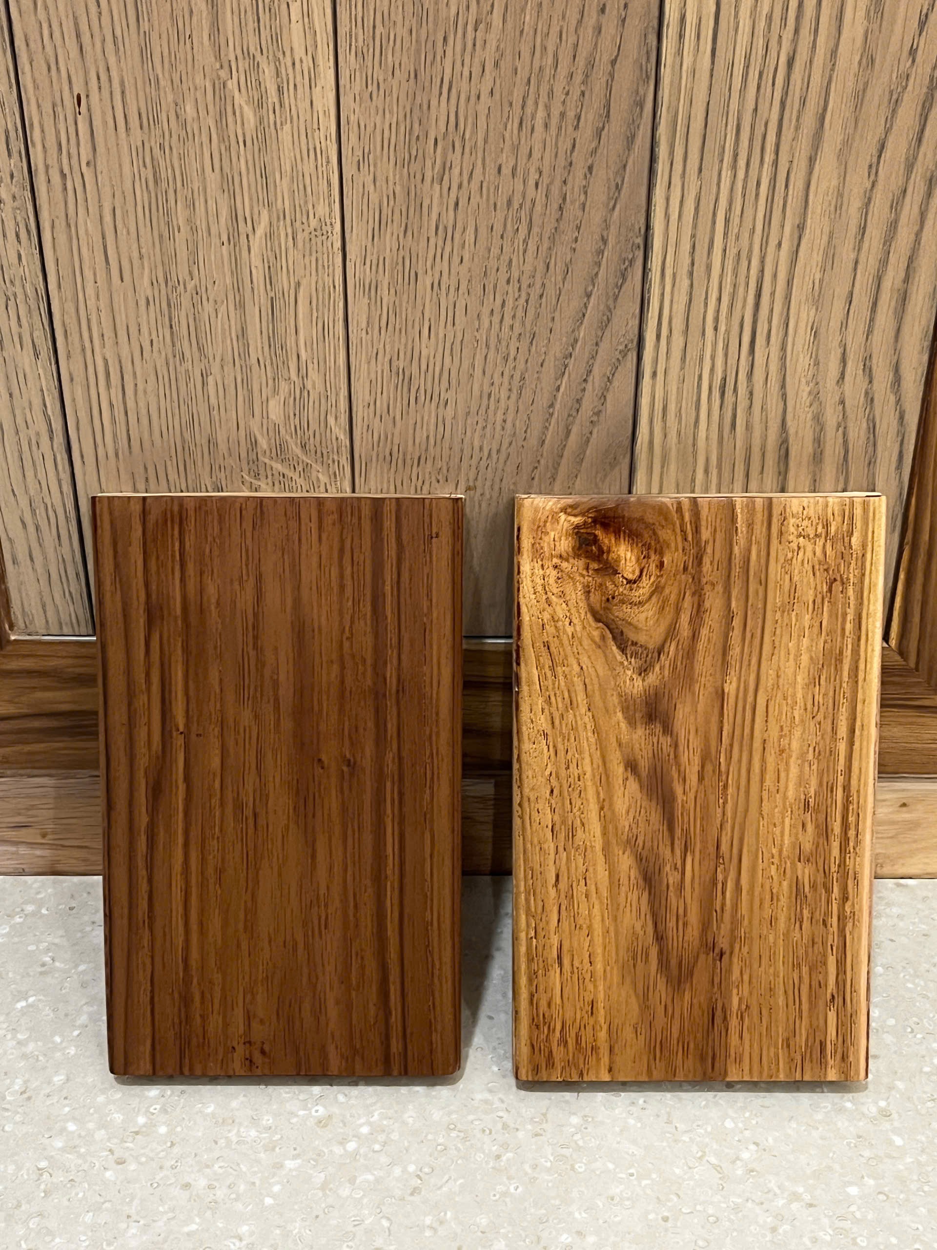 Hai mẫu gỗ Teak Lào đặt cạnh nhau, thể hiện sự khác biệt về sắc nâu và đường vân bề mặt.