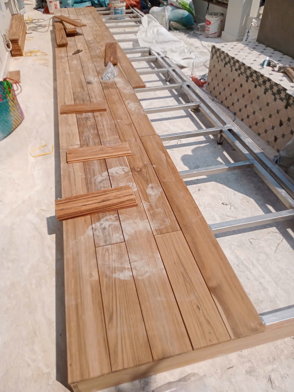 Các thanh sàn Teak Lào đang được lắp trên hệ khung kim loại ở khu hiên villa.
