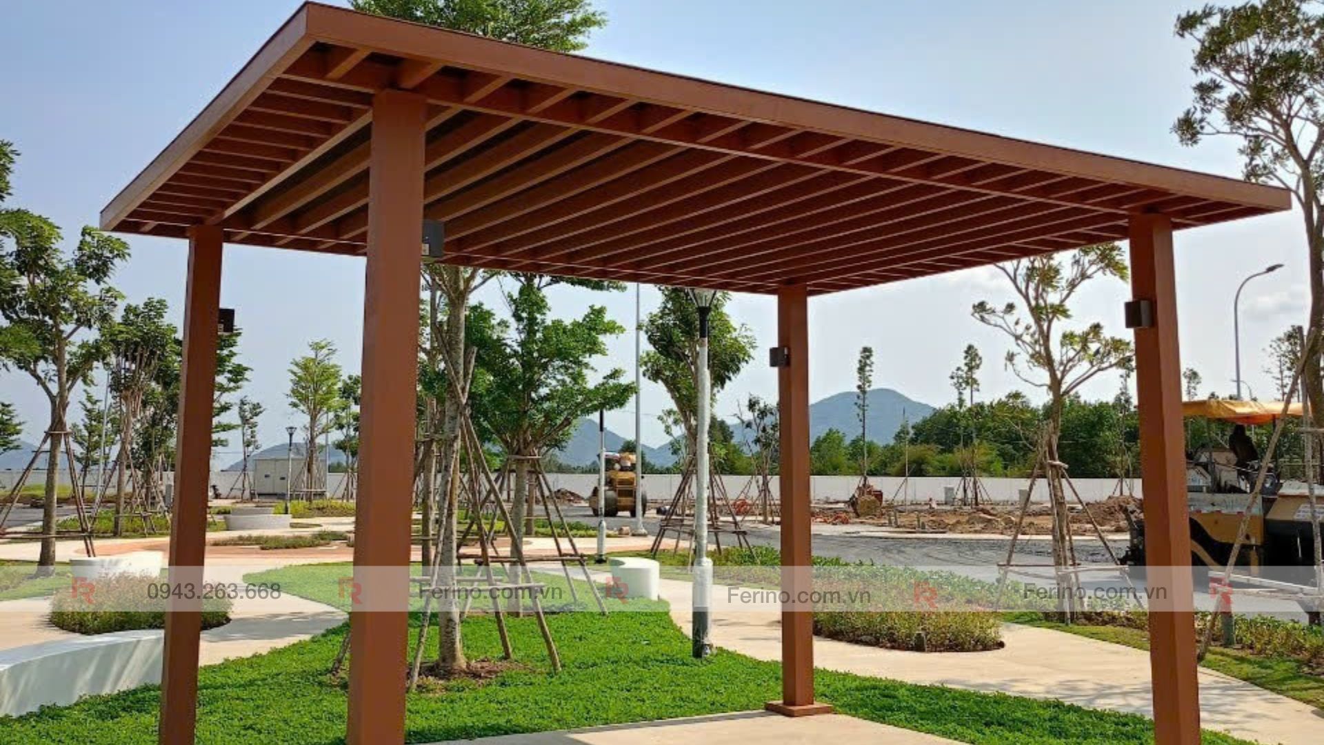 Toàn cảnh chòi có mái lam nằm giữa sân vườn với cây trồng và lối dạo xung quanh.
