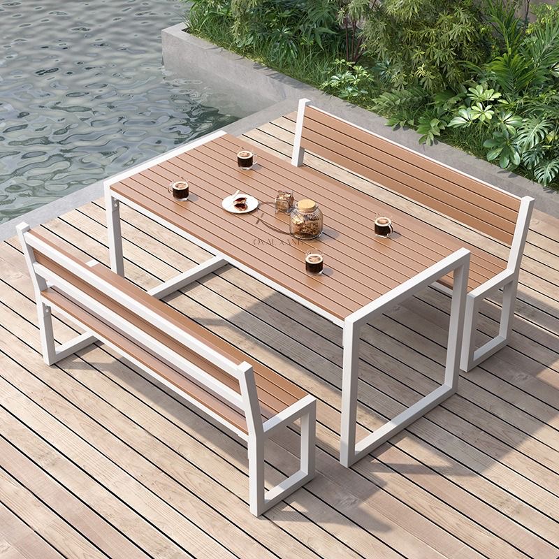 Bộ bàn ghế ngoài trời khung trắng với ghế tựa đặt trên sàn cạnh hồ nước
