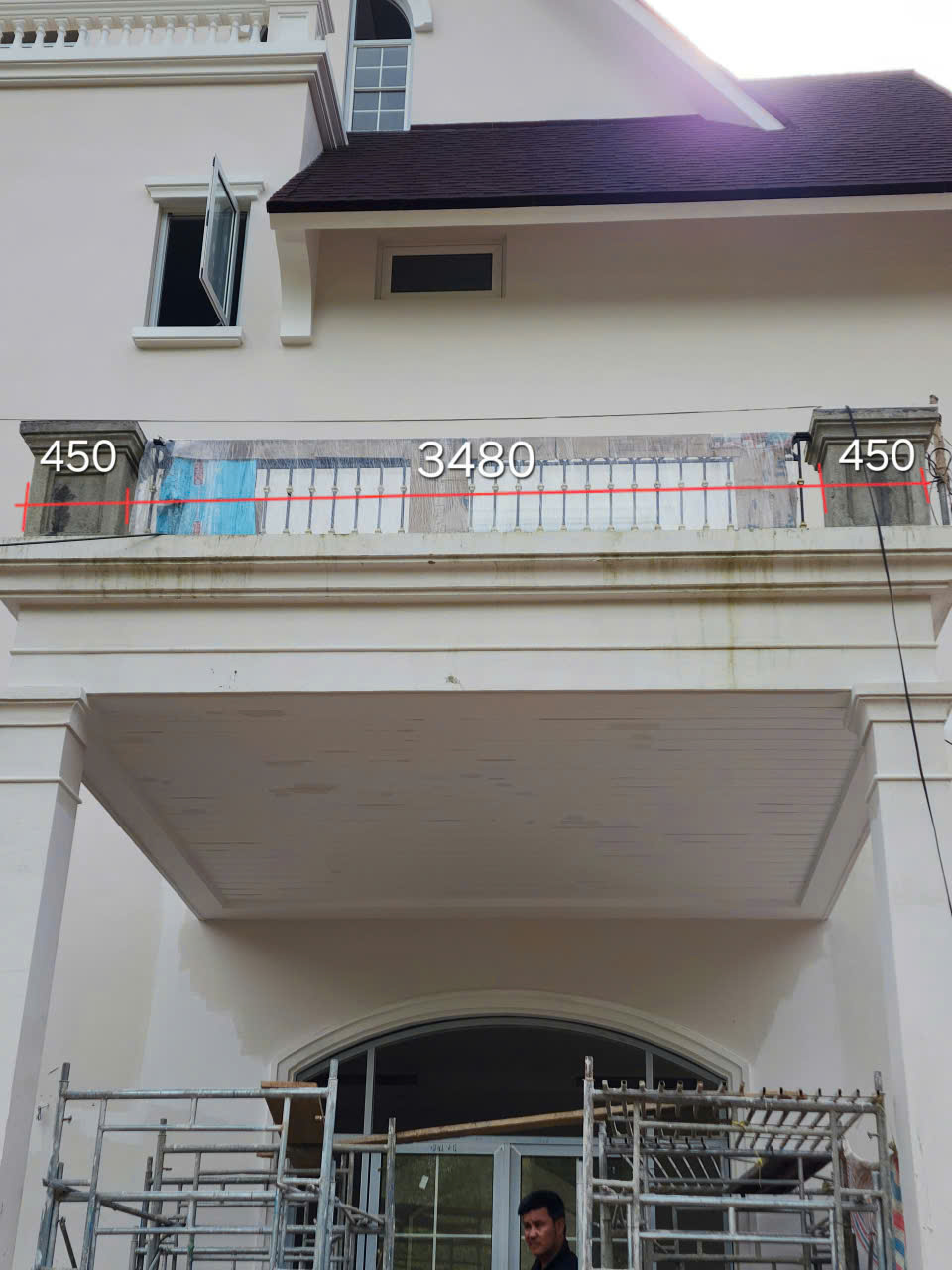 Bóng các thanh lam đổ trên lối hiên và mặt tường cạnh cửa